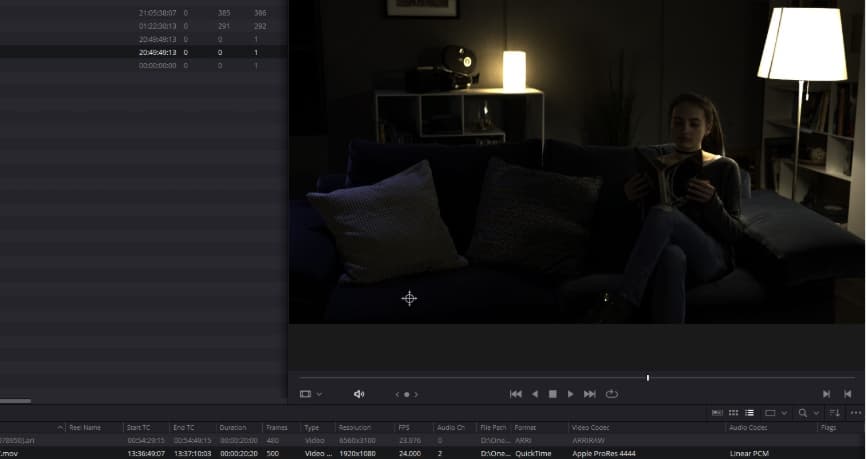 A shot in the DaVinci Resolve viewer with no Output Transform applied. The interior scene reads very dark, with only the practical lamps holding any brightness.